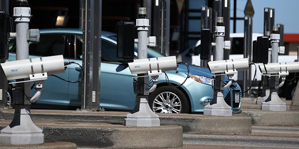 car passing through a toll booth with cameras