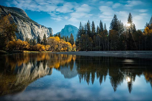 View of Half Dome above a still lake in Yosemite National Park | Top 10 States for Auto Refinance Savings