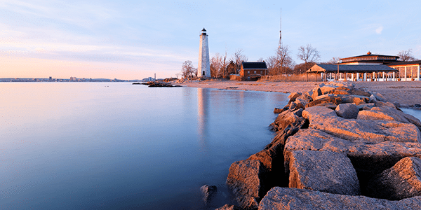 Rocky bay with a lighthouse in the distance in Connecticut | States with the best and worst credit scores