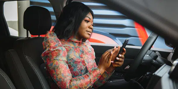 Woman using her phone while sitting in a car