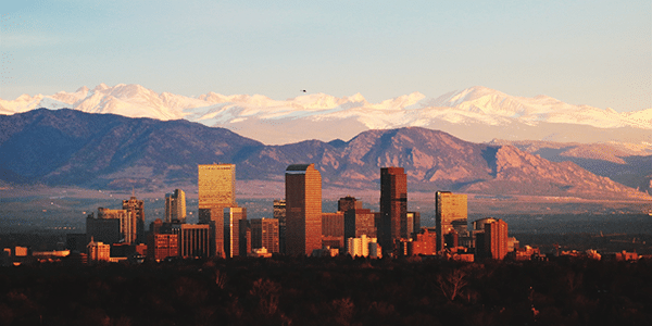 Denve, Colorado skyline with mountains in the distance | Cities With the Best and Worst Interest Rates