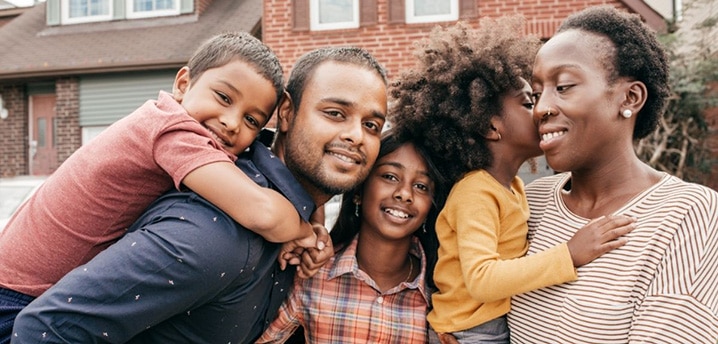 Family standing in front of a new house they bought