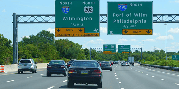 cars on a highway with signs pointing to Wilmington and Philidelphia
