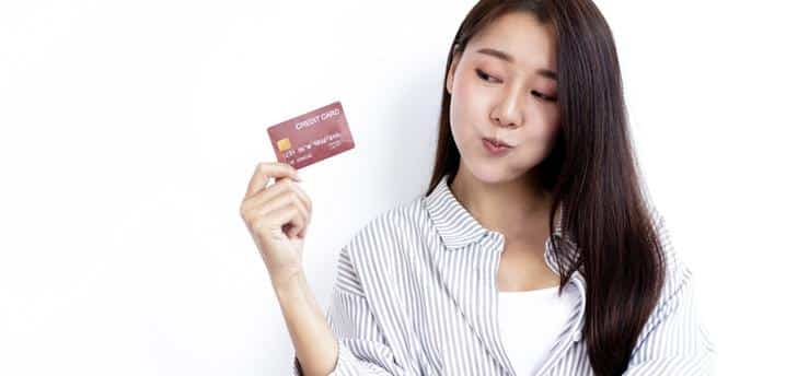 Woman smiling while holding credit card