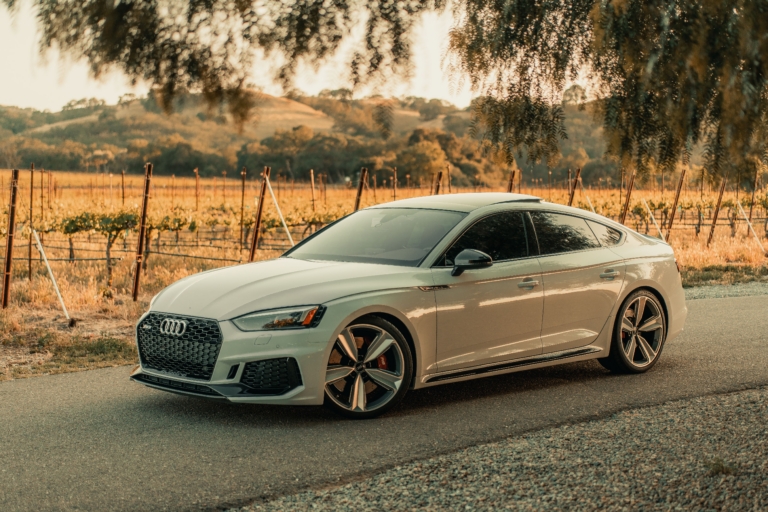 White audi on road with green background