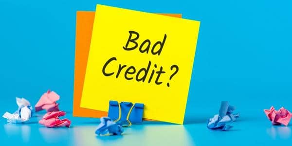 yellow sticky note that reads "Bad Credit" being held up by a clip