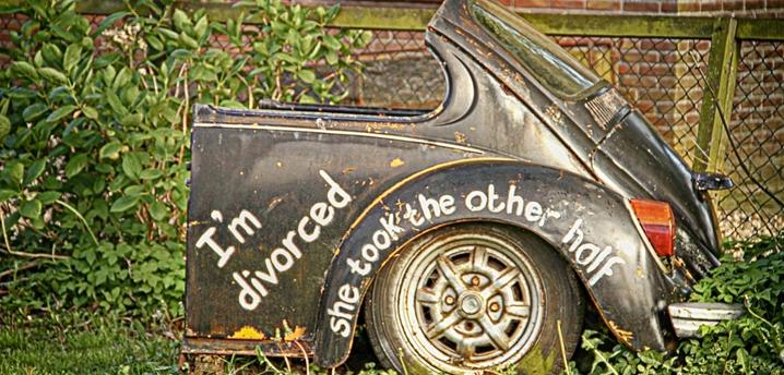 Half of a car with "I'm divorced. She took the other half" written on the car