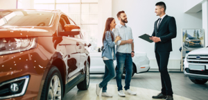 car buyers discussing down payment with salesman