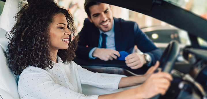 car salesman telling woman to kick the trade for new car