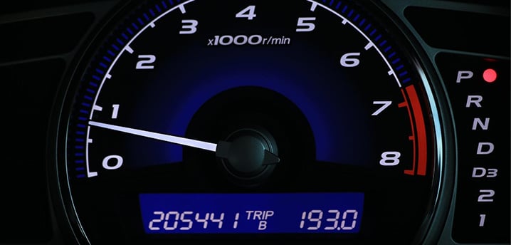 close-up of a car gauge with high miles