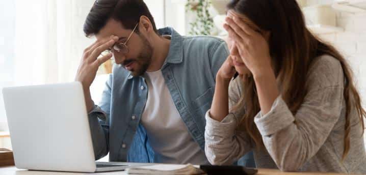 couple looking discouraged with bills