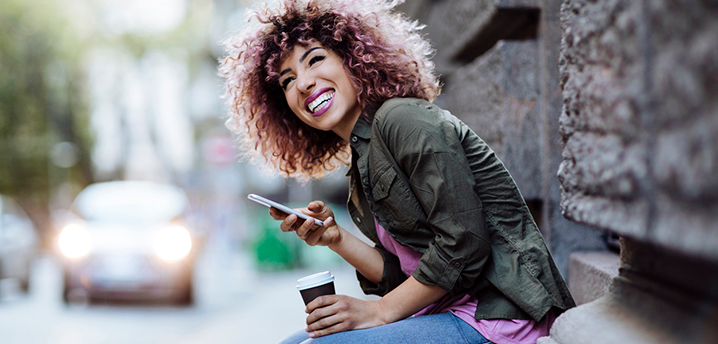 happy woman with phone checking good credit score