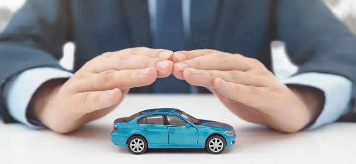 person holding hands over a toy car protectively