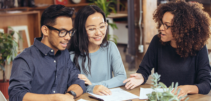 Credit union representative helping couple with financial decision