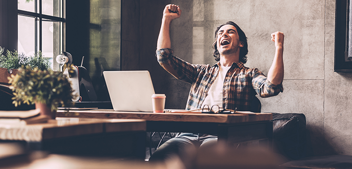 man cheering new refinance loan at coffee shop