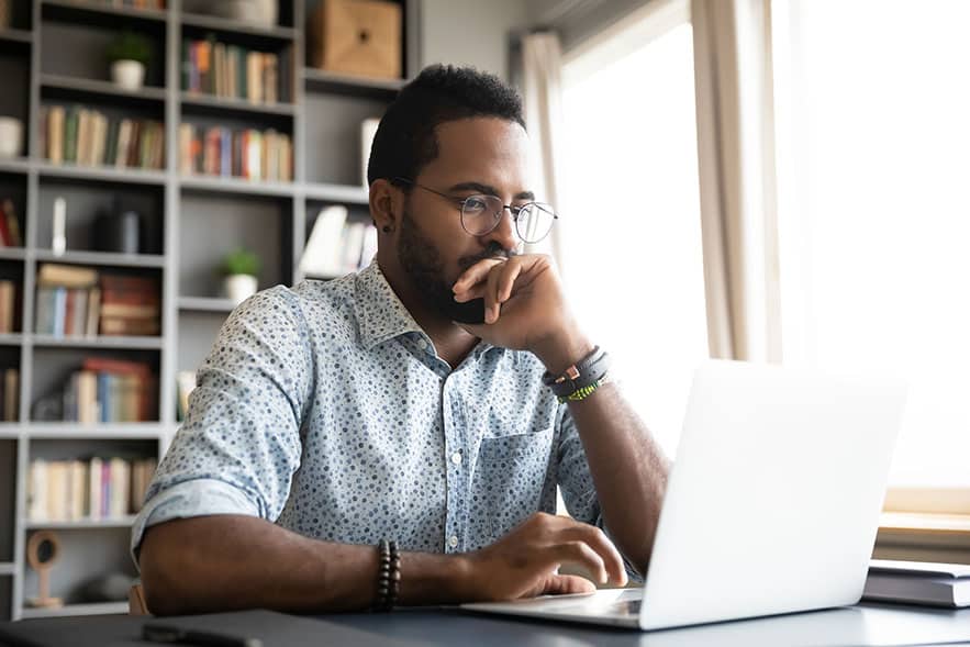 Man looking at his computer screen and appearing very focused