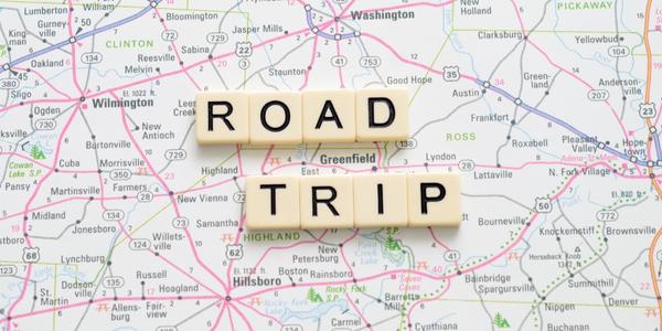 "Road Trip" spelled out in scrabble letters on top of a map