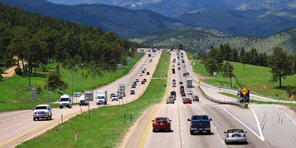 mountain landscape with cars driving on a multi-lane highway