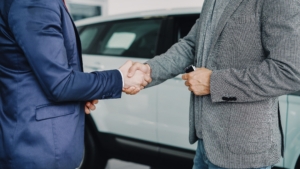 two people shaking hands from chest down.