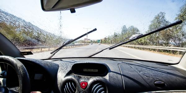 close-up of windshield wipers working on a car while it is raining