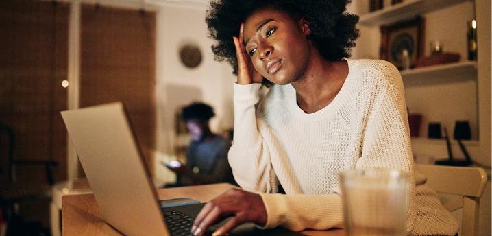 woman looking concerned while on her laptop