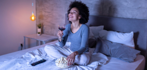 woman drinking wine watching netflix improving credit experian boost